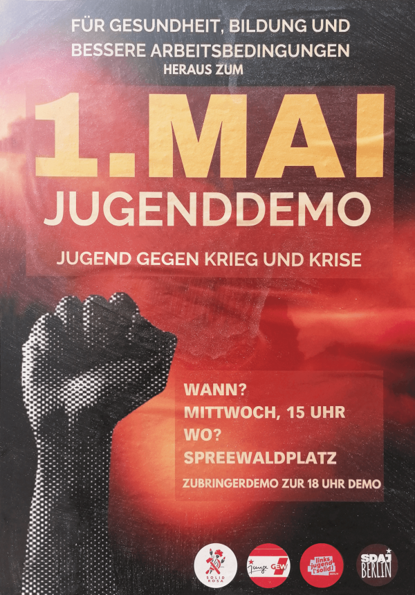 Ein Poster mit schwarzem Hintergrund und rotem Farbverlauf. Oben steht: "Für Gesundheit, Bildung und bessere Arbeitsbedingungen. Heraus zum 1. Mai Jugenddemo. Jugend gegen Krieg und Krise." In der Mitte ist ein schwarz-weißes Rasterbild einer erhobenen Faust. Unten steht: "Wann? Mittwoch, 15 Uhr. Wo? Spreewaldplatz. Zubringerdemo zur 18 Uhr Demo." Am unteren Rand sind Logos von verschiedenen Organisationen abgebildet.