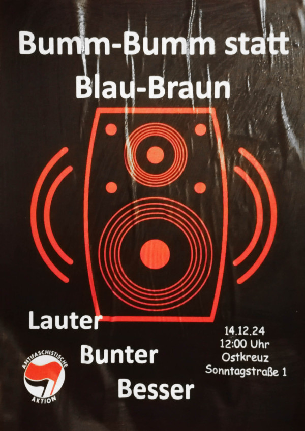 Ein Plakat mit einem roten Lautsprecher auf schwarzem Hintergrund. Der Text lautet: "Bumm-Bumm statt Blau-Braun. Lauter Bunter Besser." Veranstaltungshinweise: "14.12.24, 12:00 Uhr, Ostkreuz, Sonntagstraße 1." Logo der Antifaschistischen Aktion wird gezeigt.