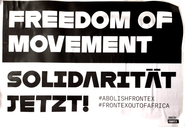 Schwarz-weißes Plakat mit großem Text. Oben steht „Freedom of Movement“ in weißer Schrift auf schwarzem Hintergrund. Darunter „Solidarität Jetzt!“ in schwarzer Schrift auf weißem Hintergrund. Rechts unten sind die Hashtags „#AbolishFrontex“ und „#FrontexOutOfAfrica“ in kleinerer Schrift zu sehen. In der unteren Ecke befindet sich ein kleines Logo mit dem Text „Abolish Frontex“.