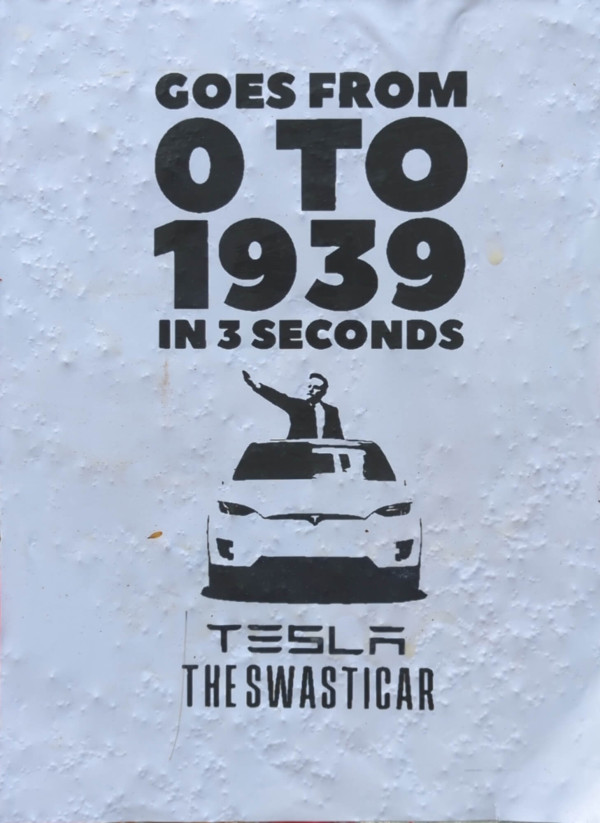 Ein Poster mit weißem Hintergrund zeigt in schwarzer Schrift den Text: "Goes from 0 to 1939 in 3 seconds". Darunter ist ein Bild eines Autos mit einer Person, die aus dem Dachfenster einen Gruß macht. Unten steht "Tesla The Swasticar" in. Das Design ist minimalistisch, mit einem starken Kontrast zwischen dem weißen Hintergrund und der schwarzen Schrift.