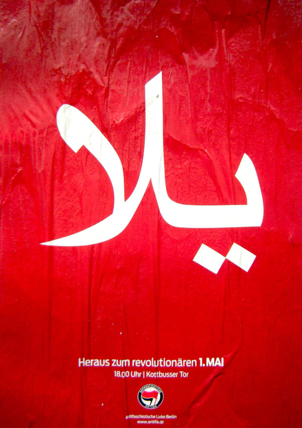 Rotes Plakat mit großer weißer arabischer Schrift. Darunter steht: "Heraus zum revolutionären 1. Mai, 18.00 Uhr, Kottbusser Tor" mit einem Logo und "Antifaschistische Linke Berlin, www.antifa