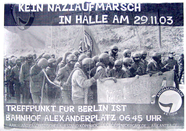 Schwarzes und weißes Plakat, das eine Gruppe antifaschistischer Demonstranten mit Helmen zeigt, die ein Transparent halten. Der Text lautet: "Kein Nazi-Aufmarsch in Halle am 29.11.03. Treffpunkt für Berlin ist Bahnhof Alexanderplatz 06:45 Uhr."